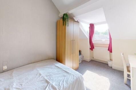 A bright and cozy single bedroom featuring a co...