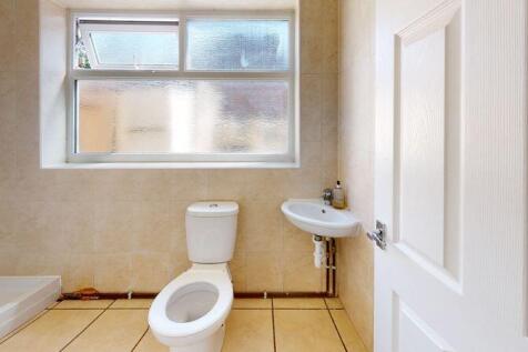 A bright and clean bathroom featuring a toilet,...