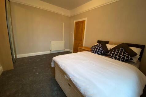 A cozy double bedroom featuring a neatly made b...