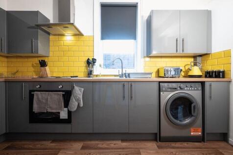 A modern kitchen featuring sleek grey cabinetry...