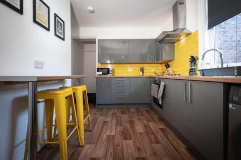 A modern kitchen featuring stylish grey cabinet...