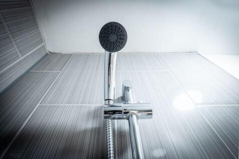 A modern bathroom shower fixture with sleek, cl...