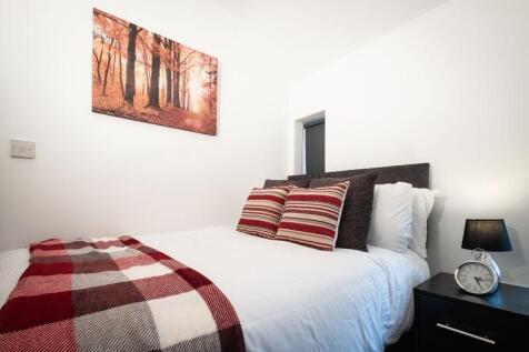 A cozy, neatly arranged bedroom featuring a com...