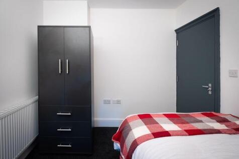 A neat and simple single bedroom featuring a co...