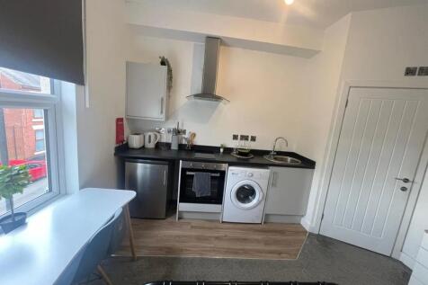 A bright and modern kitchen area featuring a sl...