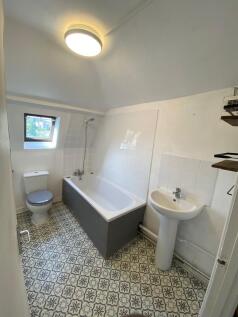 Bright bathroom featuring a patterned tiled flo...