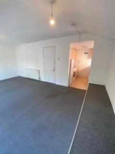 A spacious living room with clean white walls a...