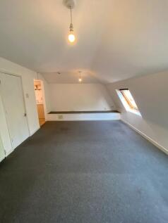 A simple, clean room featuring a slanted ceilin...