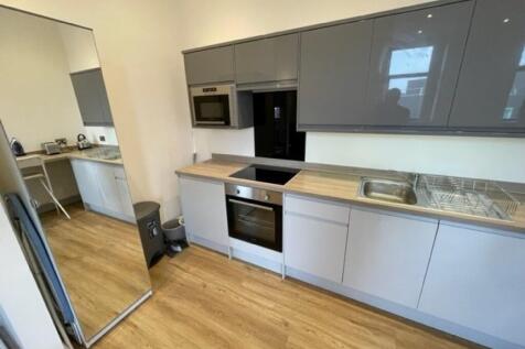 Modern kitchen with sleek grey cabinets, built-...