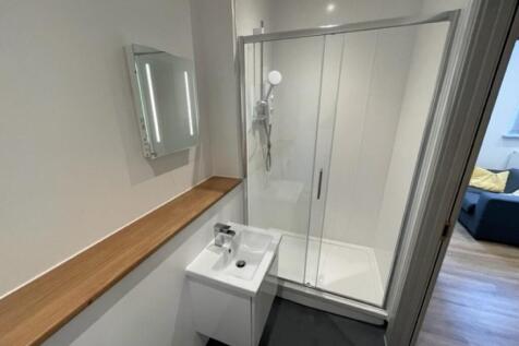 A modern bathroom featuring a clear glass slidi...