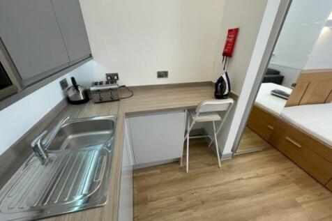 A modern and tidy kitchen area featuring a stai...