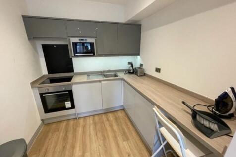 A modern, compact kitchen featuring sleek cabin...