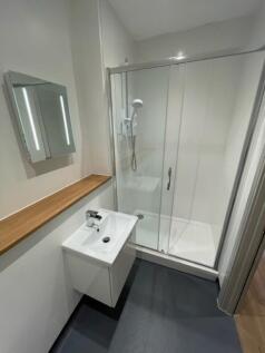 A modern bathroom suite featuring a sleek glass...