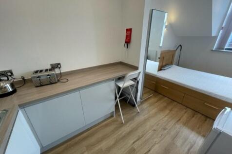 Bright and tidy single bedroom featuring a wood...