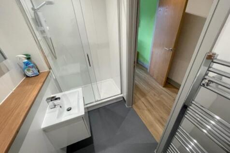 A modern bathroom featuring a glass shower encl...