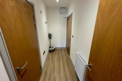 A clean and modern hallway with wood-effect flo...