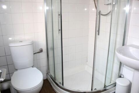 A clean, modern bathroom featuring a corner sho...