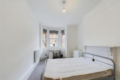 Bright and airy master bedroom featuring a larg...