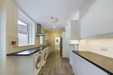 A sleek, modern kitchen featuring ample counter...