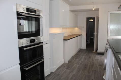 A sleek and modern kitchen featuring clean whit...