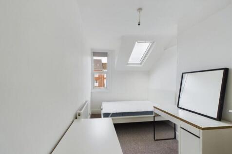 A bright and clean single bedroom featuring a s...