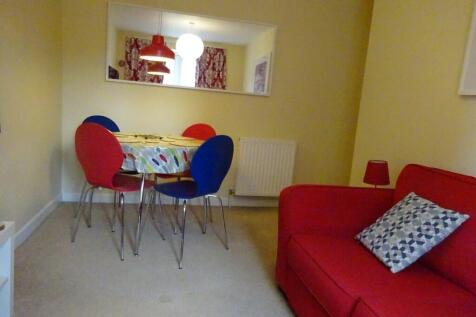 A cozy living room featuring a vibrant red sofa...