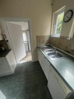 A compact kitchen space featuring a double stai...