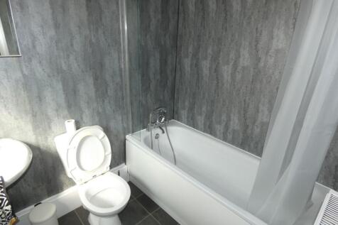 Modern bathroom featuring a clean white bathtub...
