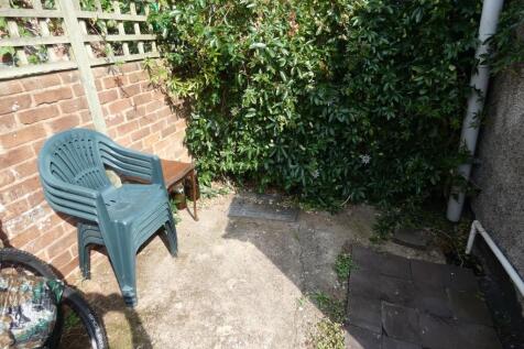 A small, sunny outdoor garden area featuring a ...