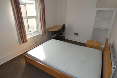 Bright single bedroom featuring a large window ...