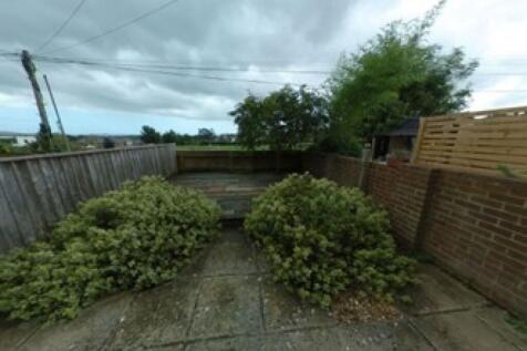 A charming garden area featuring a paved patio ...