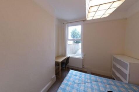 A neat single bedroom featuring a bright window...