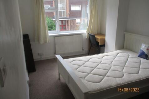 A bright single bedroom featuring a clean white...