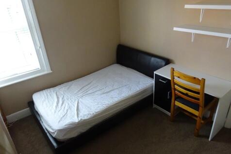 A cozy single bedroom featuring a comfortable b...