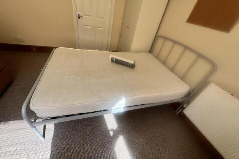 A tidy double bedroom featuring a metal frame b...