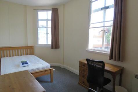 A bright single bedroom featuring two large win...