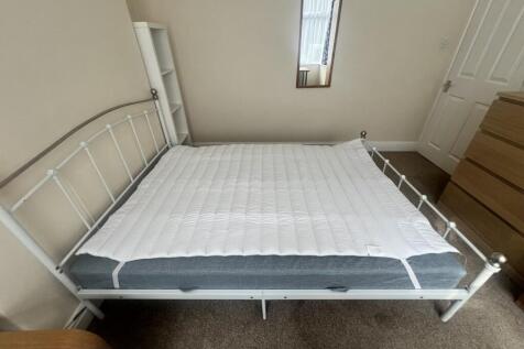 A neat and tidy double bedroom featuring a clea...
