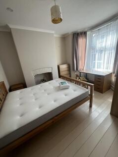 Bright double bedroom featuring a large window ...