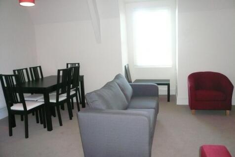 A bright and tidy living room featuring a comfo...