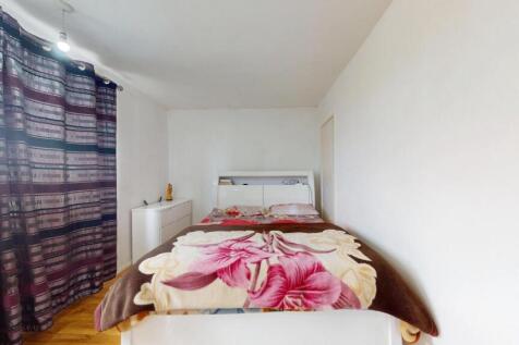 A clean, well-lit single toilet room with a whi...