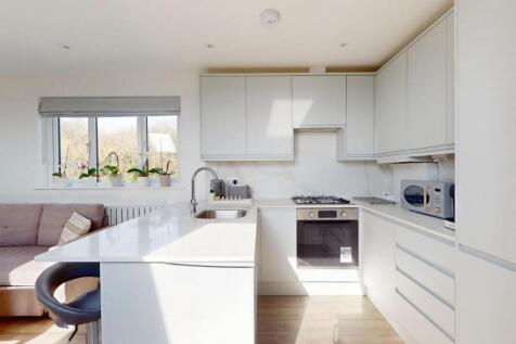 Bright and modern kitchen featuring sleek white...