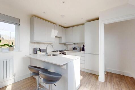 Bright and modern kitchen featuring sleek white...