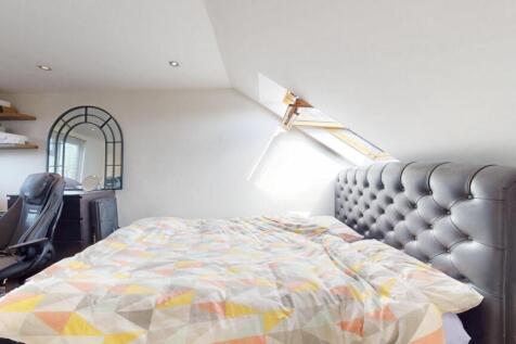 A spacious and cozy attic bedroom with a large ...