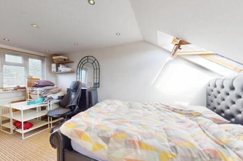Bright and cozy attic bedroom featuring a comfo...