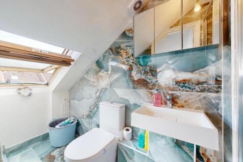A modern bathroom suite featuring a large skyli...