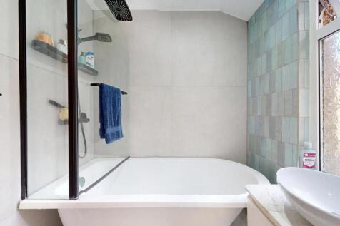 Bright bathroom suite featuring a modern bathtu...