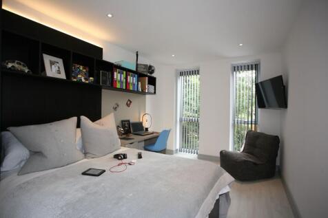 A modern and well-lit master bedroom featuring ...