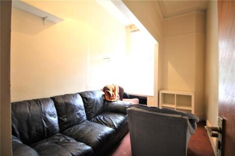 A cozy living room featuring a black leather so...