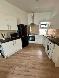 Bright, modern kitchen with sleek white cabinet...