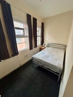 A cozy double bedroom featuring a metal bed fra...
